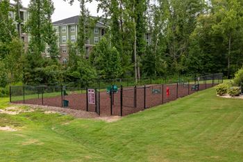 A green lawn with a fence and a sign.